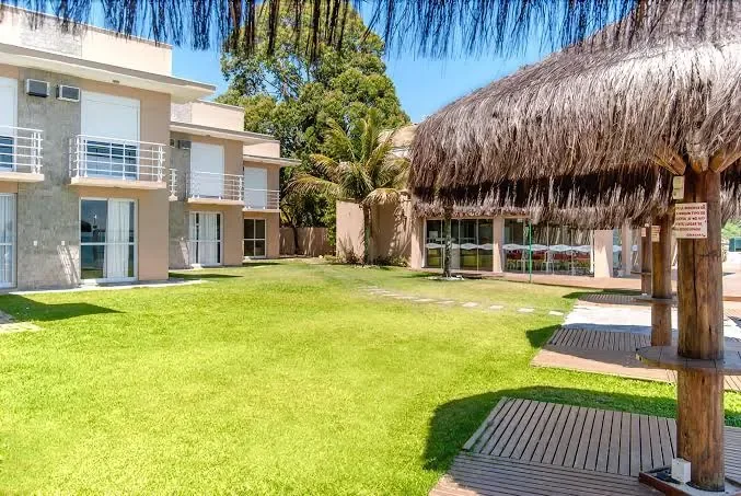 Blocos de duplex de frente para o gramado, com quiosque de palha