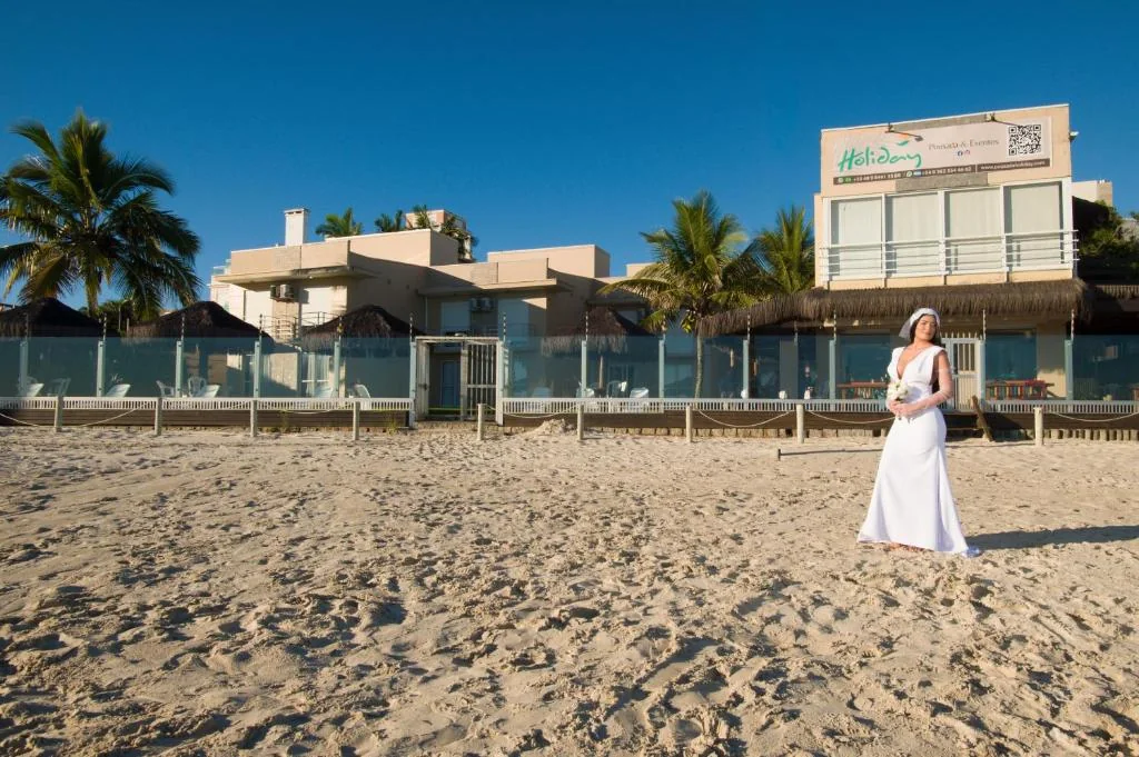Noiva na areia em frente à Pousada Holiday